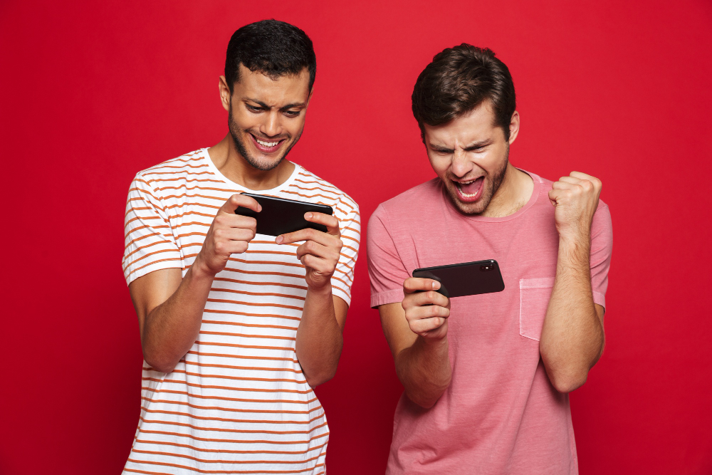två unga män spelar mobilspel i mobilen.